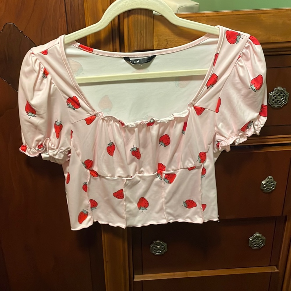 A pink shirt with strawberries on it, and is also cropped